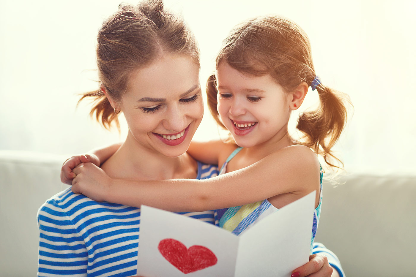 mère et sa fille tenant une carte de fête