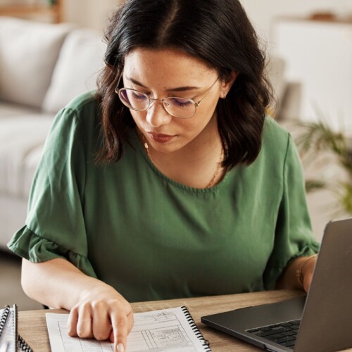 Jeune femme devant un ordinateur portable qui fait un budget - Comment faire un budget pour gérer ses finances - Blogue | Multi-Prêts Hypothèques