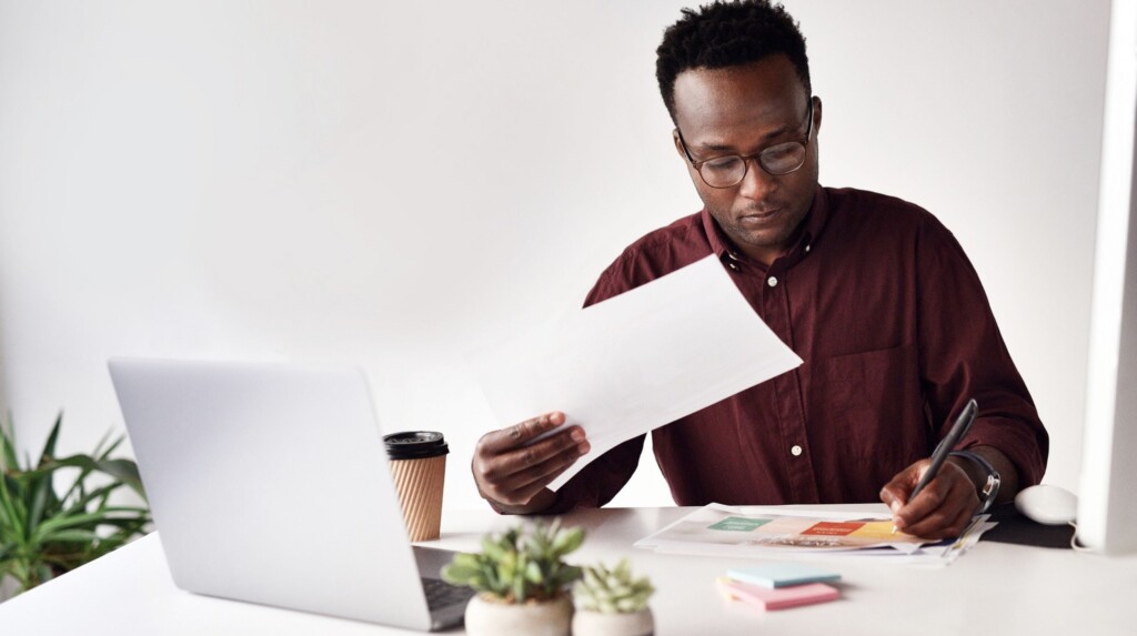 Homme devant un ordinateur portable qui fait un budget - Comment faire un budget pour gérer ses finances - Blogue | Multi-Prêts Hypothèques