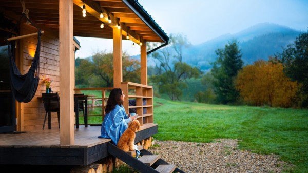 Une femme et un chien sur la terrasse d'un chalet - Multi-Prêts Hypothèques