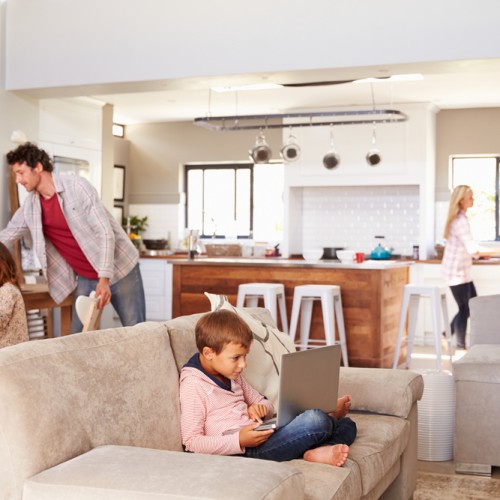 Une famille occupée au salon et dans la cuisine dans une maison à aire ouverte