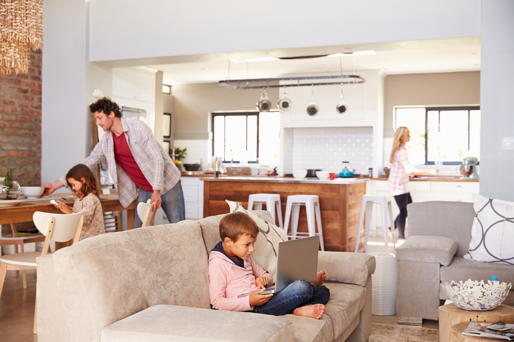 Une famille occupée au salon et dans la cuisine dans une maison à aire ouverte