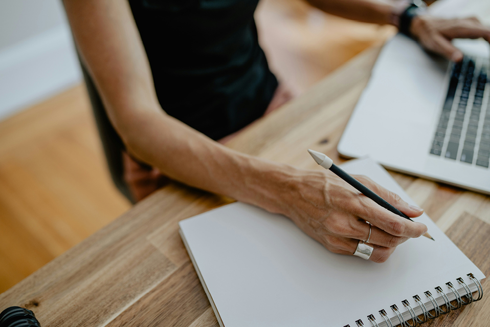 Femme qui écrit dans un cahier - Ratio d'endettement | Multi-Prêts Hypothèques