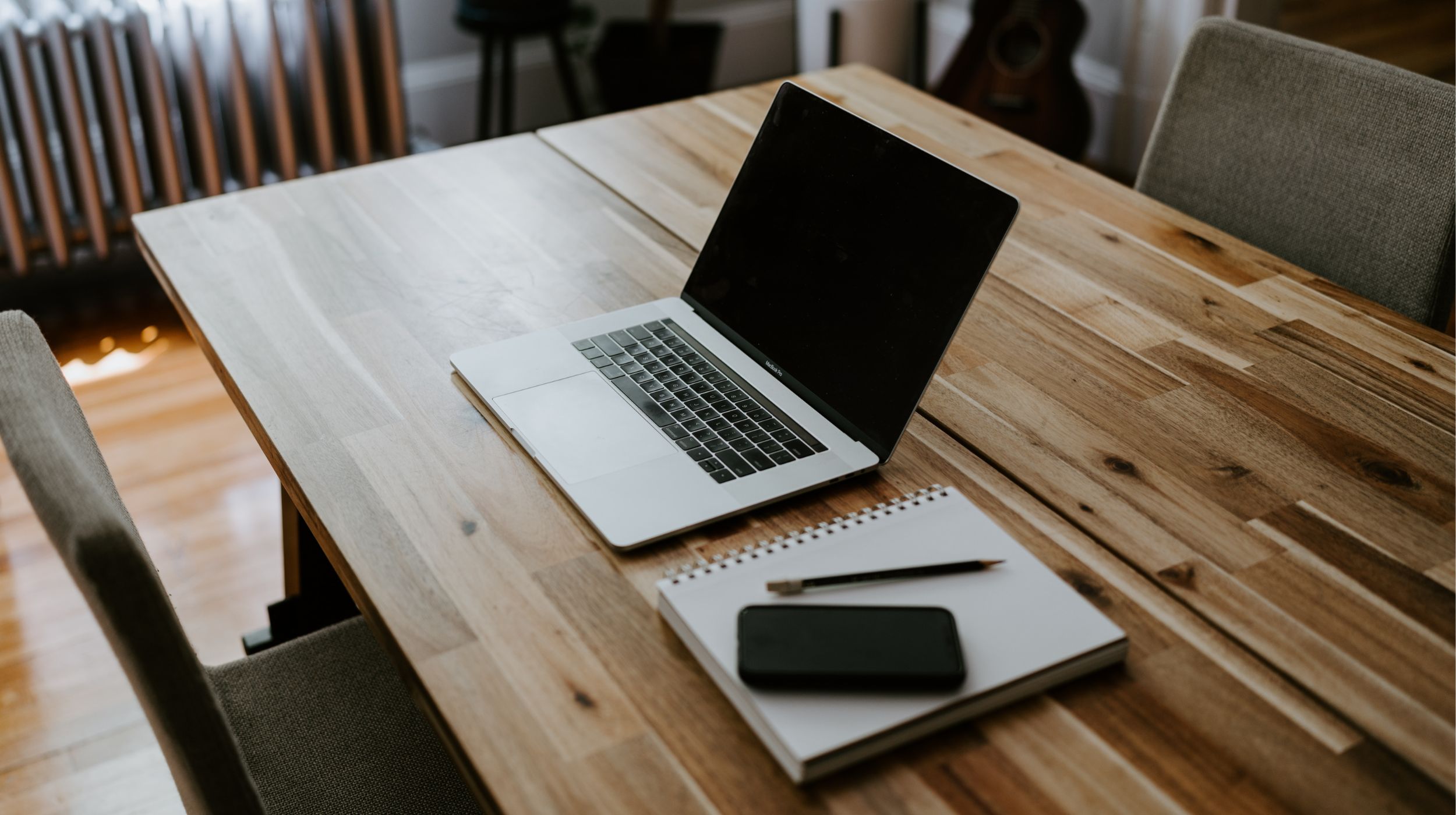 Wooden table with laptop, telephone, notebook and pencil - An exceptional career - Reward - Careers | Multi-Prêts Hypothèques